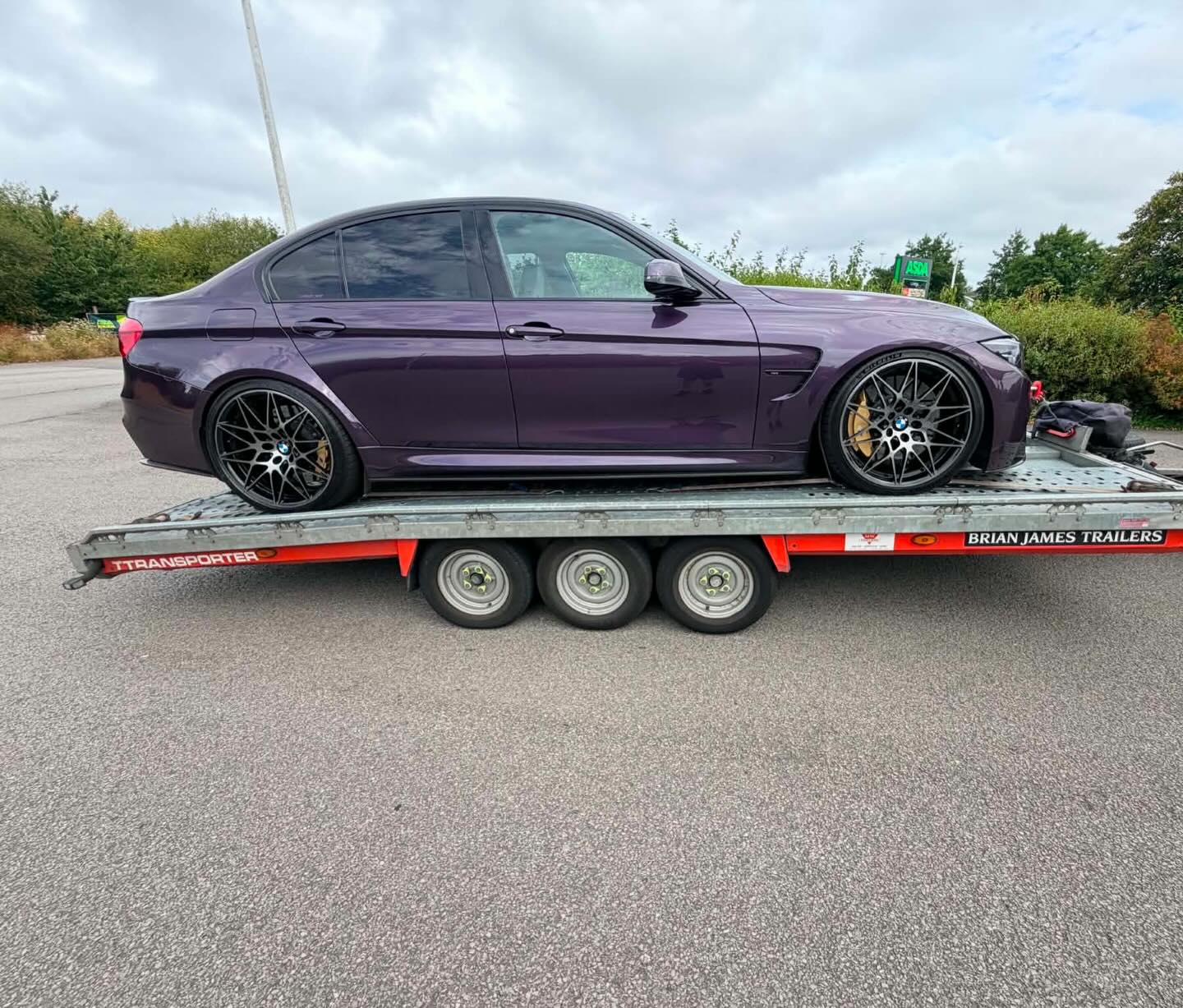 Purple BMW M3 on a transport trailer, heading to Aylesbury